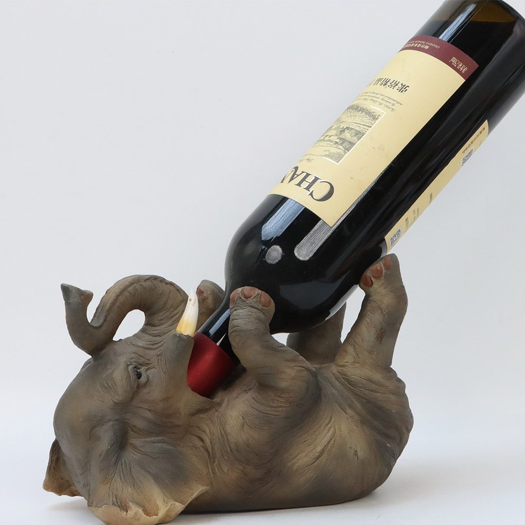 Home decor of an elephant holding a red wine bottle